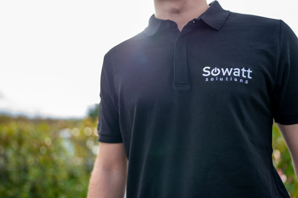 Expert technique Sowatt Solutions en polo logoté, assurant la maintenance et le suivi d'une installation de recharge électrique.